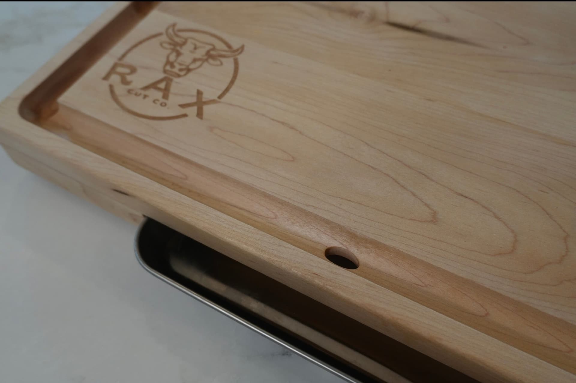 RAX Cut Co. hardwood cutting board with branded bull mark